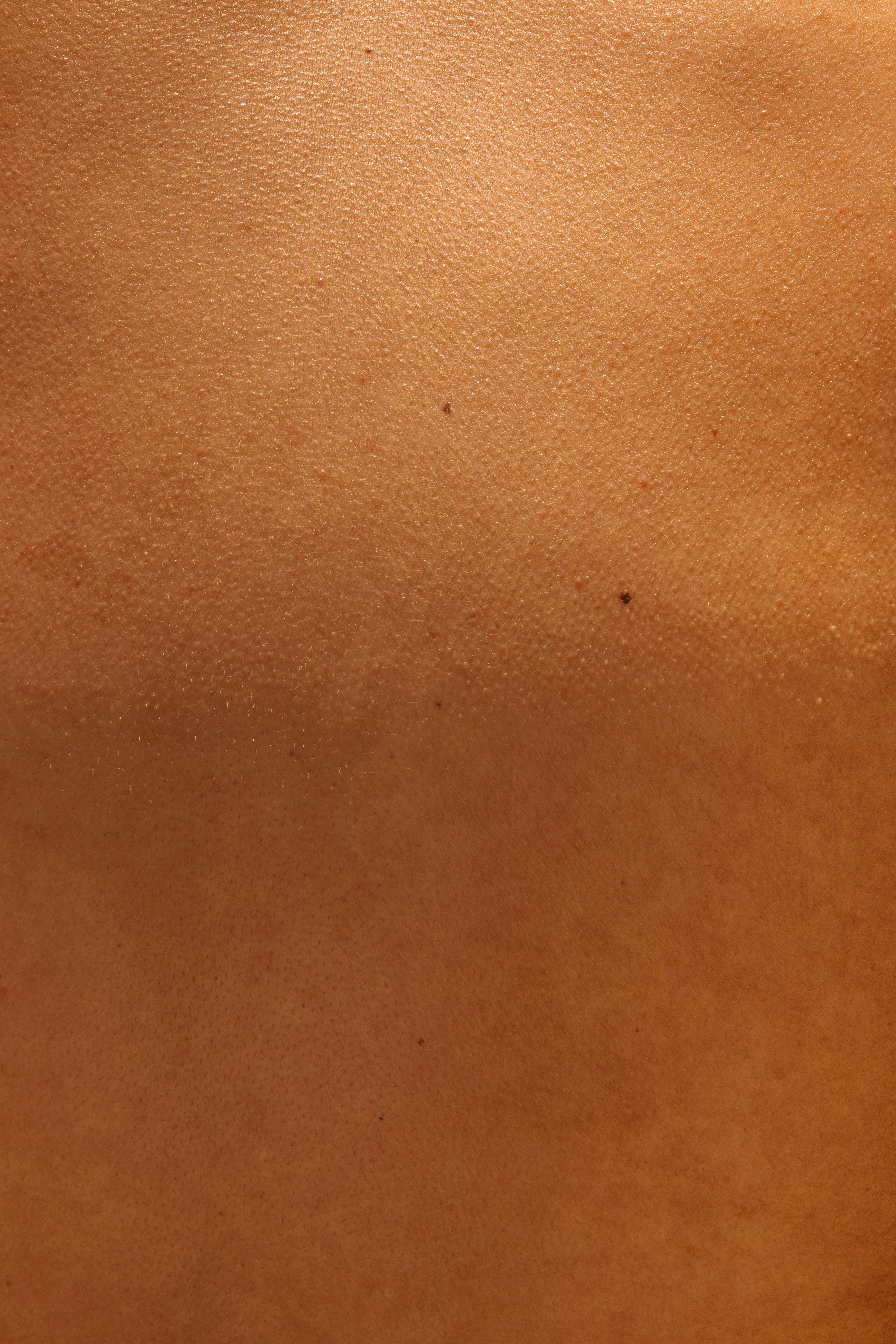 Close-up of human skin texture in warm golden light