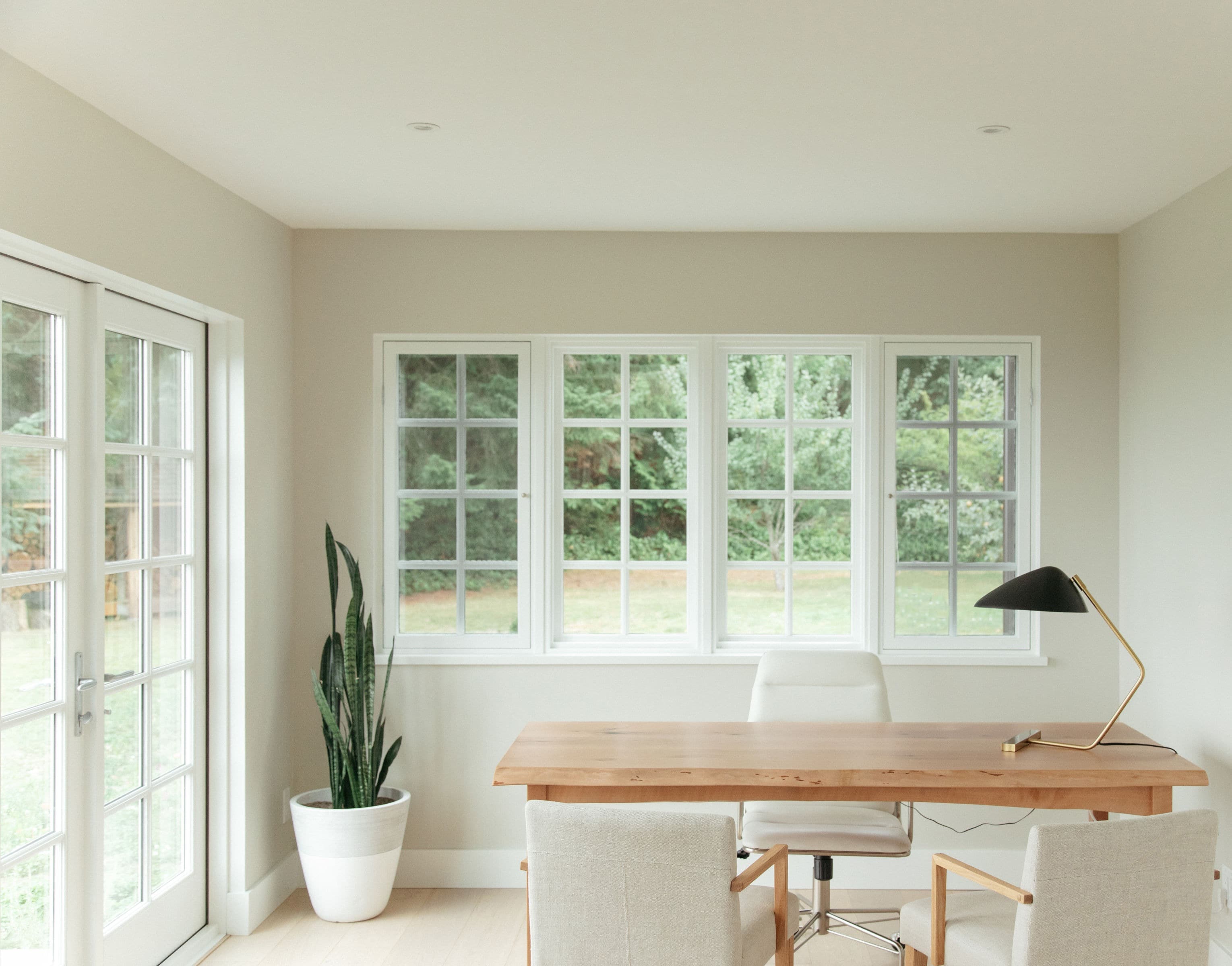 Calm, light-filled office interior with a wooden desk and garden view