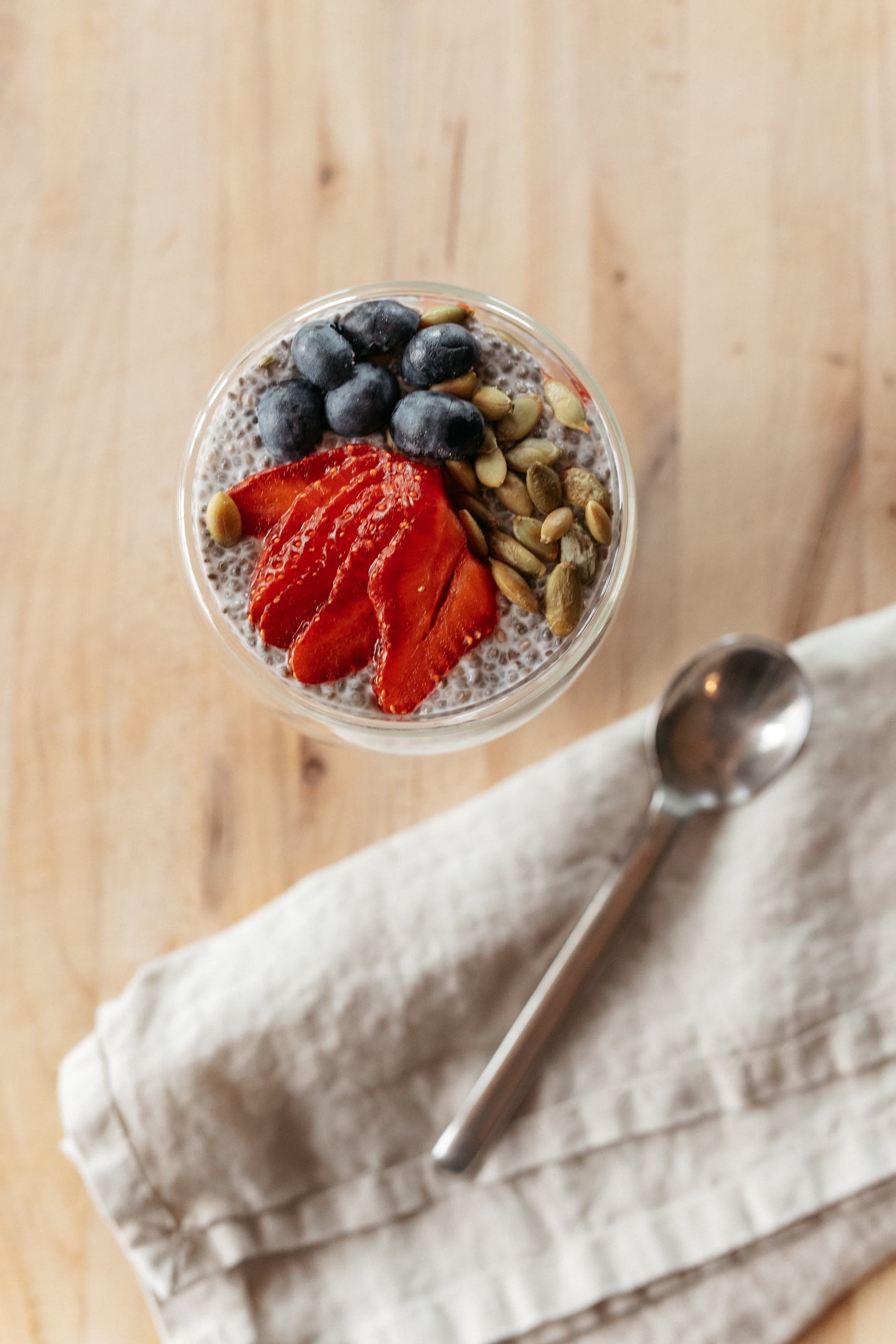 Chia pudding topped with strawberries, blueberries, and pumpkin seeds