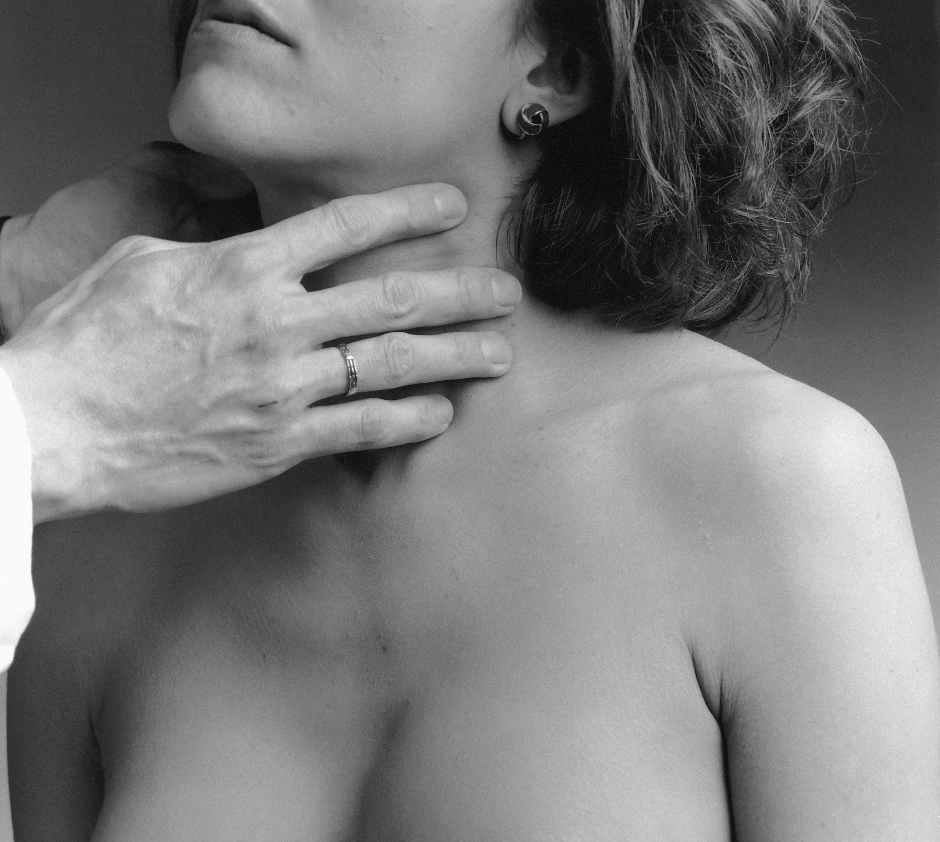 Doctor palpating a woman's thyroid gland